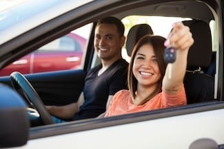 image of a couple in a car with a woman holding up a key